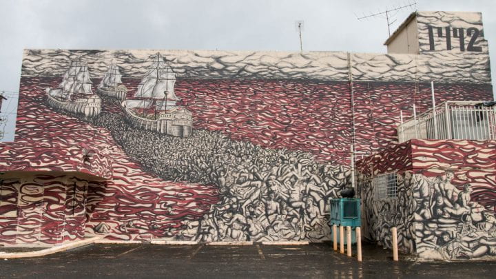 Mural in San Juan showing Columbus' three ships sailing away from the New World through a sea of blood, bodies in their wake